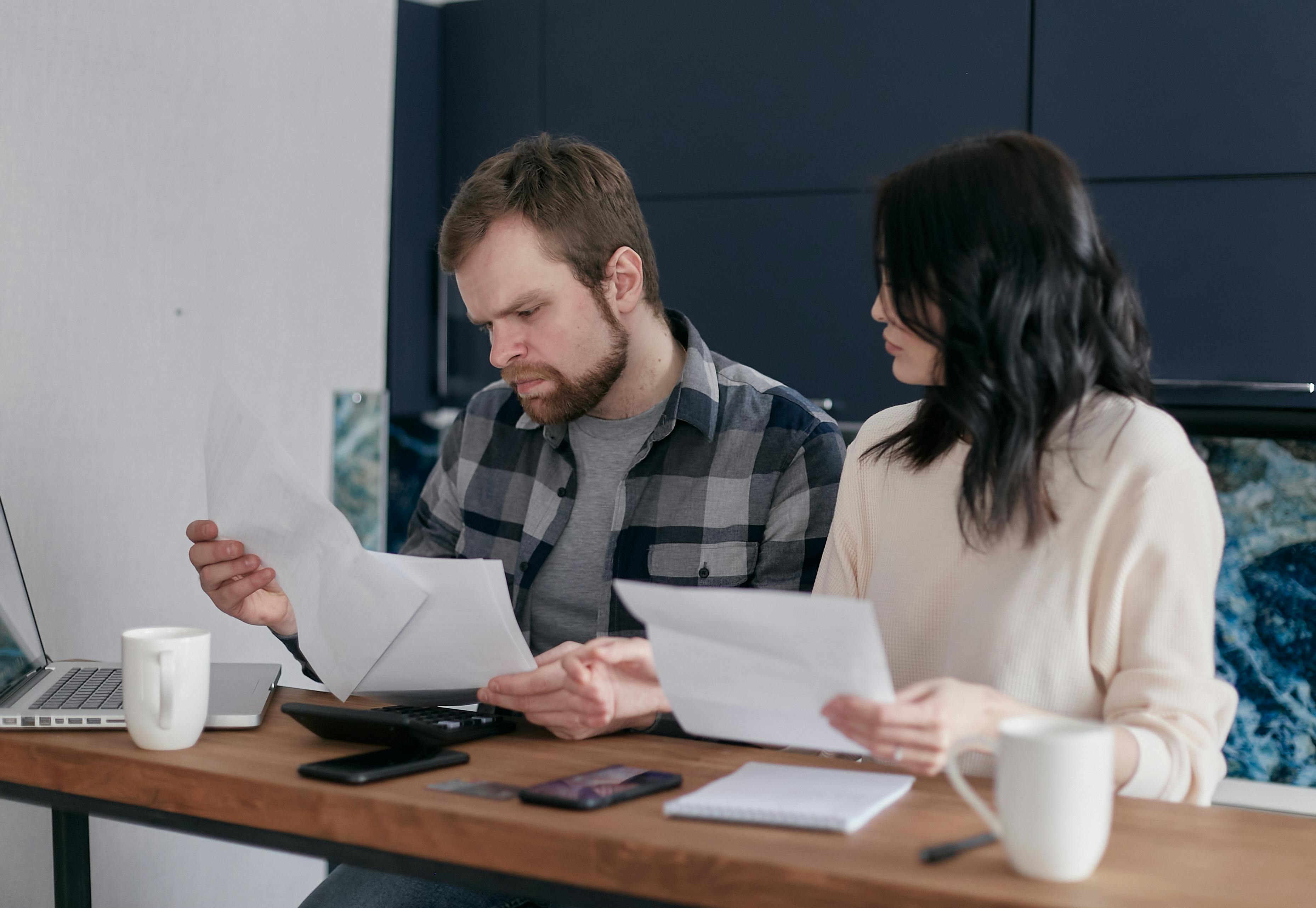 Professional couple managing finances and credit card optimization at a modern workspace